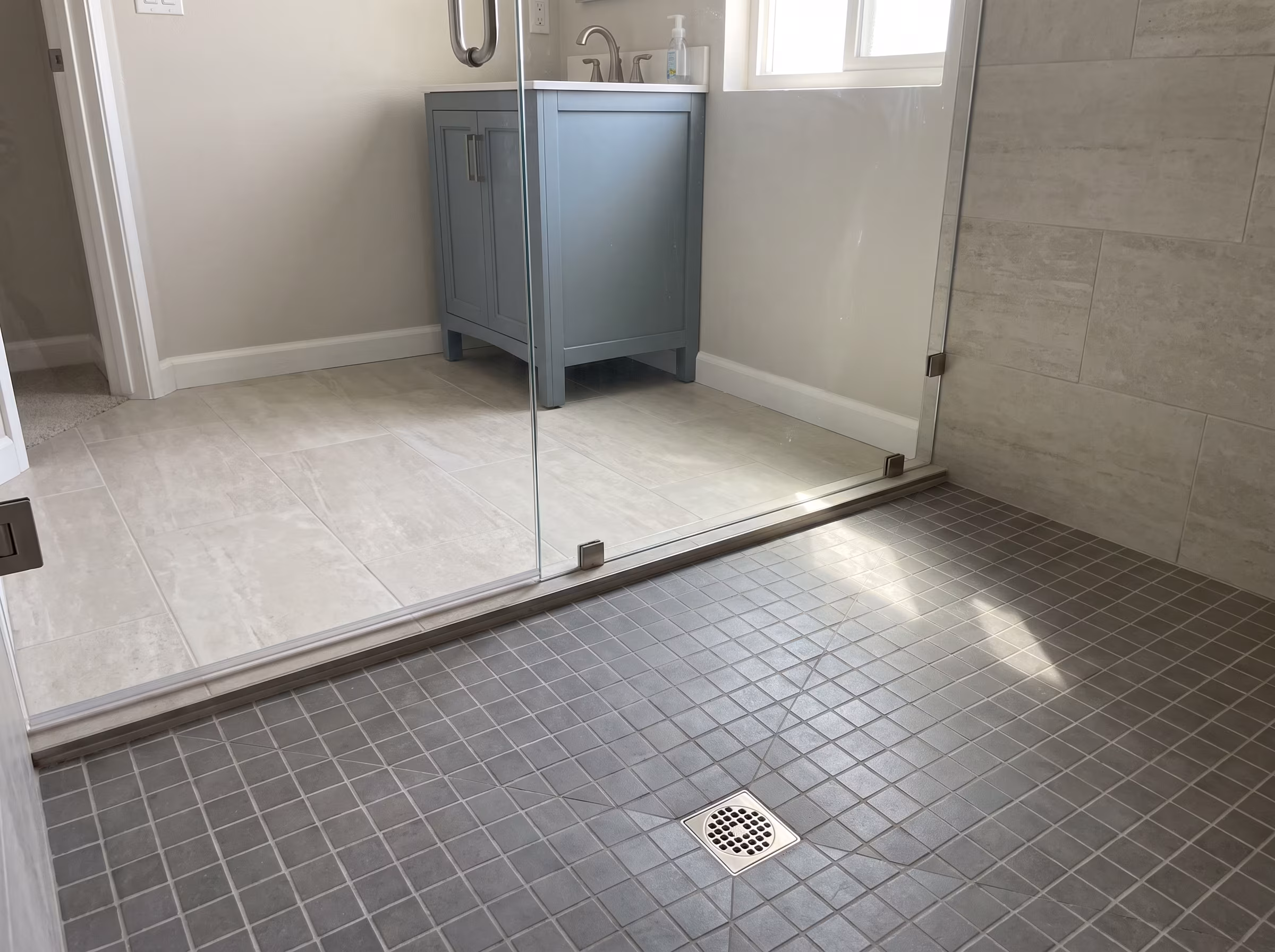 Large-format light grey bathroom floor tile with thin grout lines
