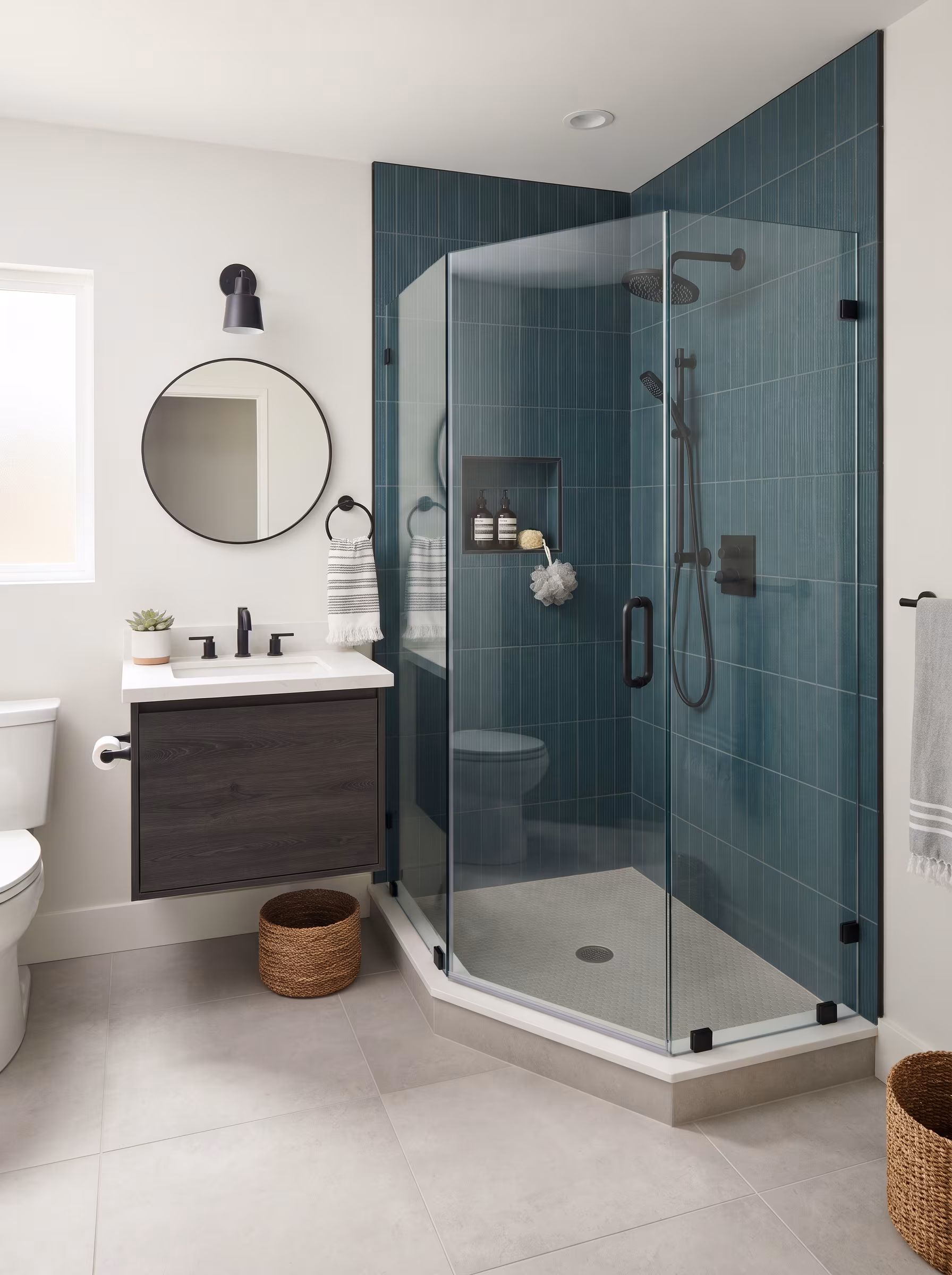 Corner walk-in shower with frameless glass, marble tile and a grab bar