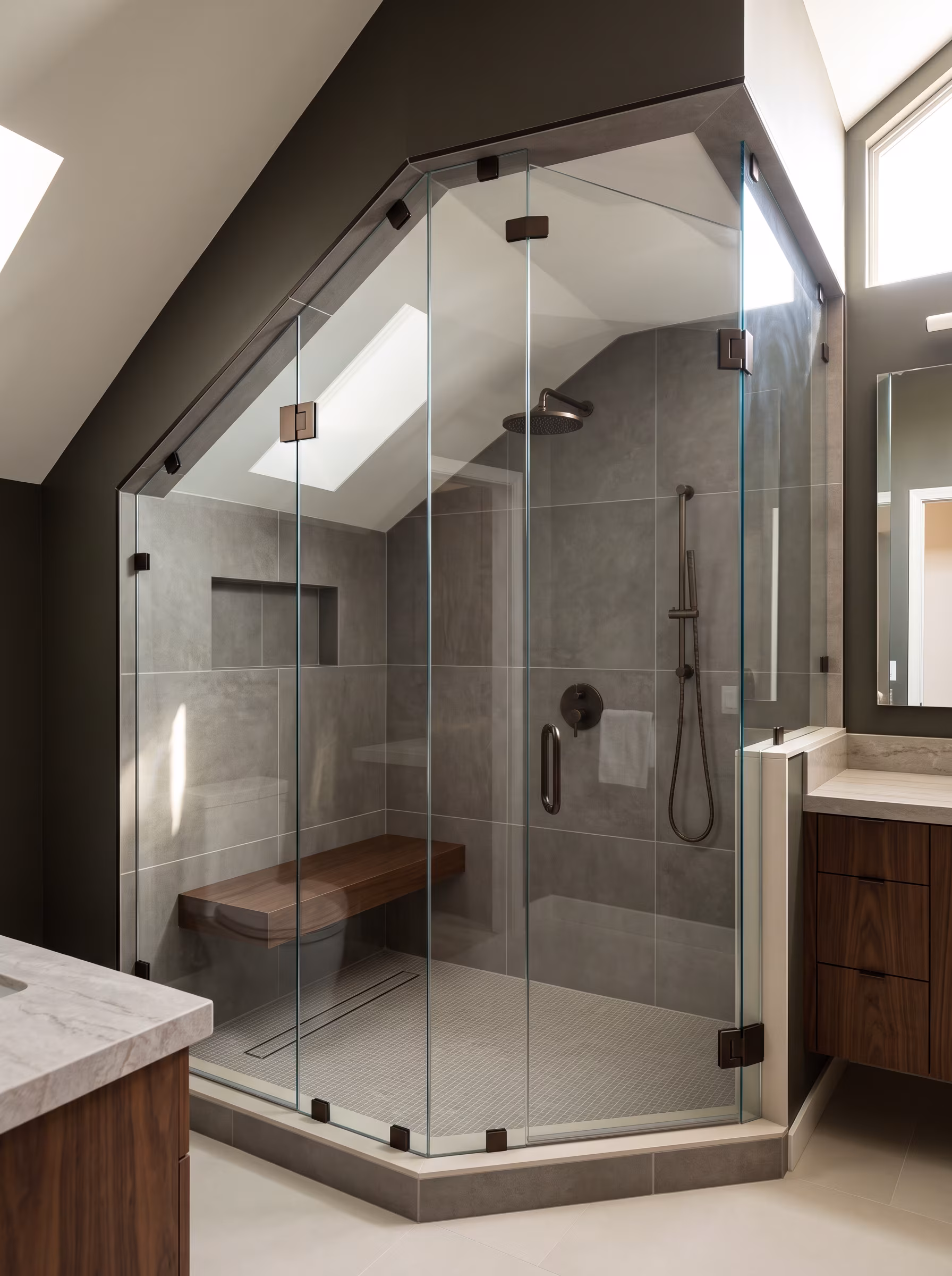 Custom walk-in shower with marble walls, glass panel and a tiled bench